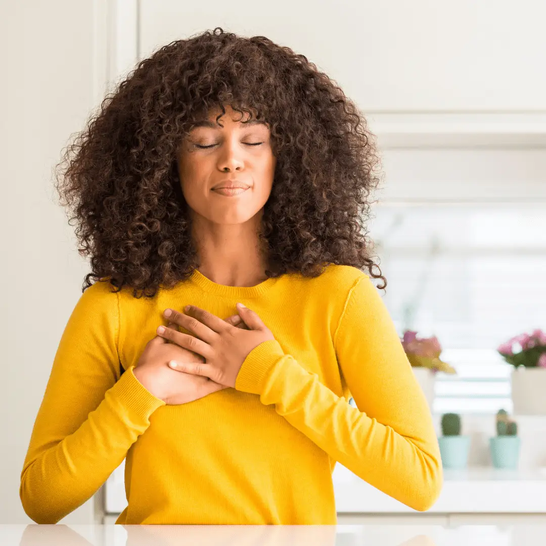 The image features a woman with both hands in chest.