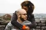 This picture shows a lovely photo of a couple on a piggy back pose in a scenic overview.