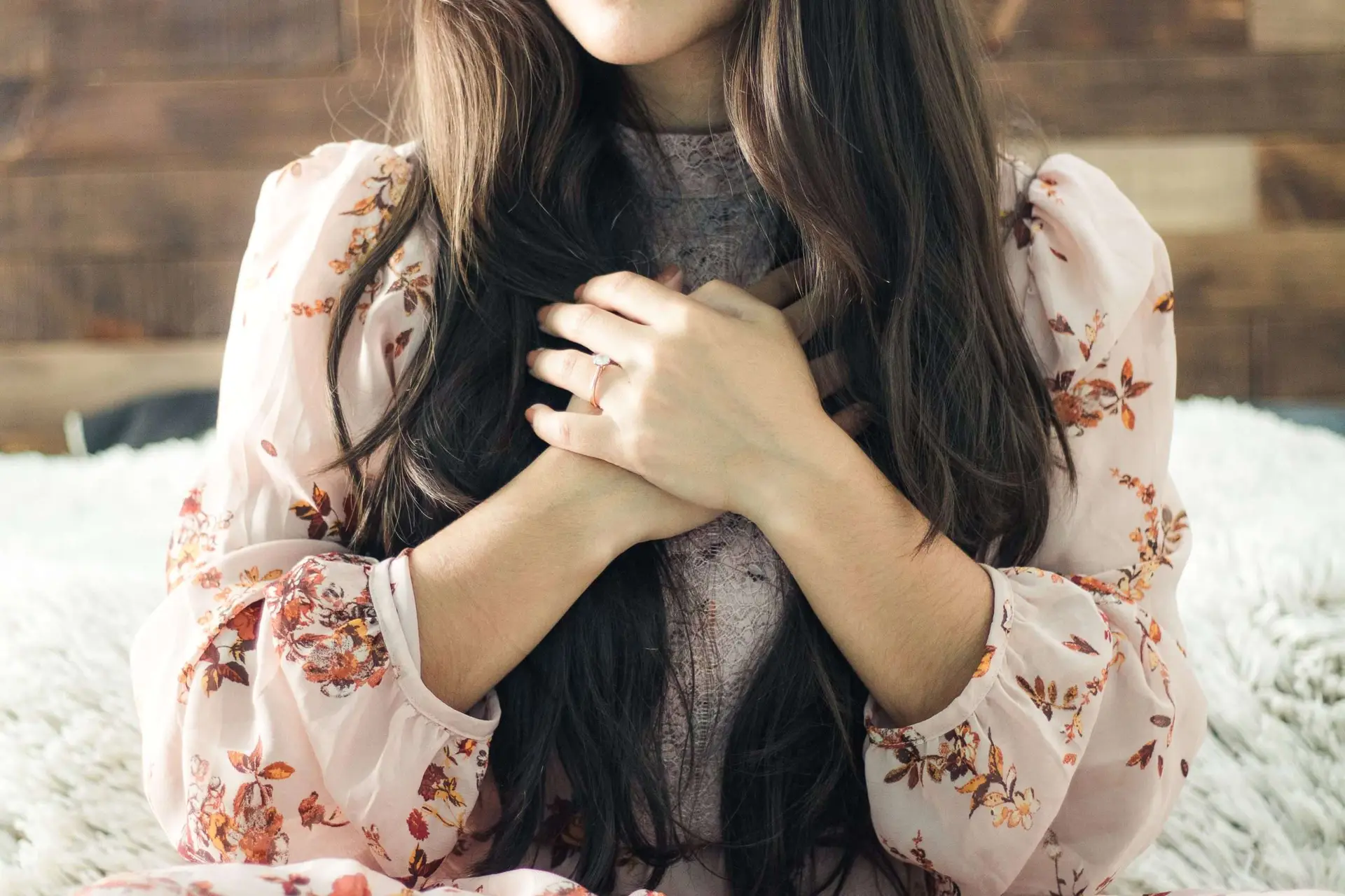 This photo shows a woman with both hands on her chest.