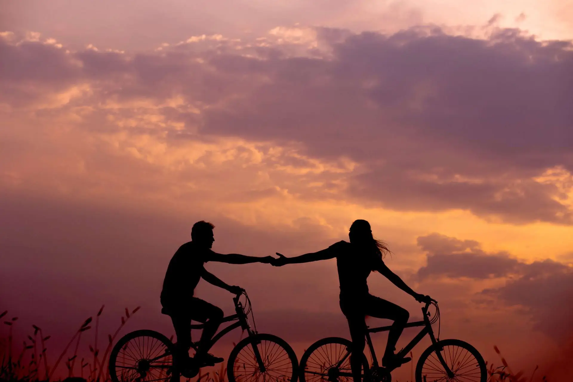 A creative photo of two lovers riding a bicycle on a field.